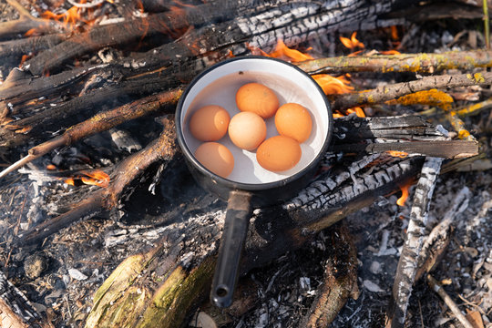 Eggs in a Cast Cauldron full Boiling Water on a Camping Fire