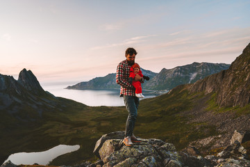 Fototapeta premium Travel family father hiking with baby outdoor in mountains vacations man with child healthy lifestyle adventure journey in Norway