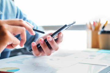 Business man using smart phone and laptop to work at office. Business and technology concept.