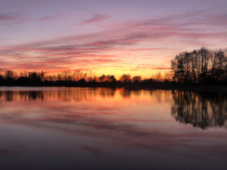 Naklejka na ściany i meble Sunset reflection in a lake around Zelhem