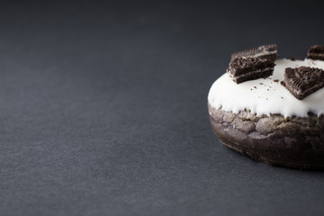 chocolate donut in white glaze on a black background