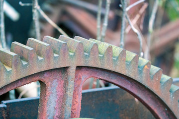 Old rusty pulley system with cog wheel and steel wire.