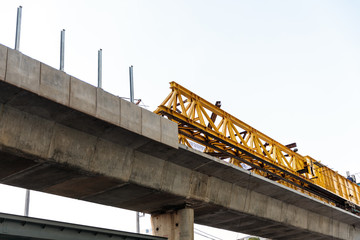 Bridge under construction in city, yellow steel structure stayed on bridge