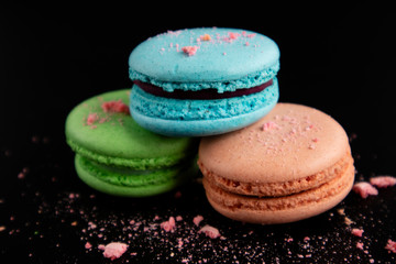 Macaroons on a black background. Sweet pastries.