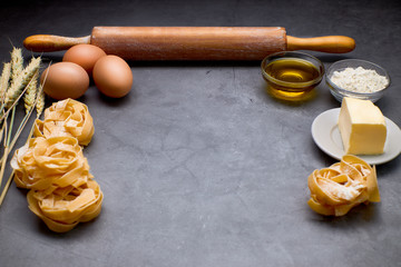 Italian pasta with some eggs, oil, flour, wood kneader and wheat.