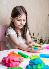 Obraz na płótnie Canvas Little girl playing with colorful clay. Homemade plastiline. Plasticine. play dough. Girl molding modeling clay. Homemade clay.