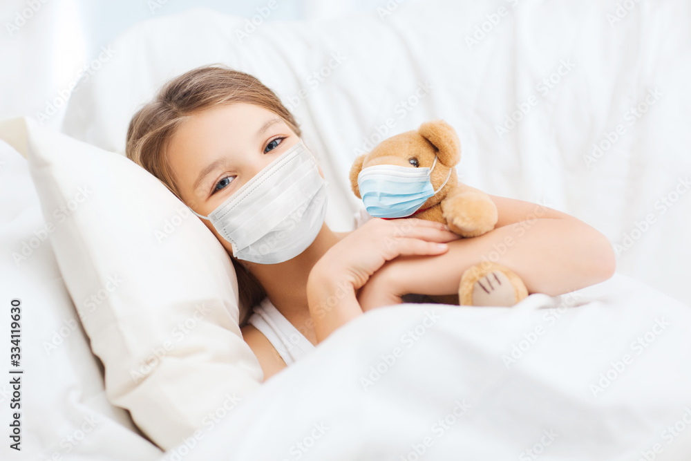 Poster health safety, quarantine and pandemic concept - girl in protective medical mask with teddy bear in bed