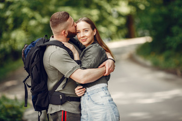 Couple in a forest. Man with a backpack. Woman in a green jacket