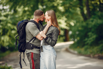 Couple in a forest. Man with a backpack. Woman in a green jacket