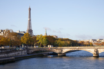 Eiffel tower, bridge and Seine river view with autumn trees in a sunny day in Paris, France