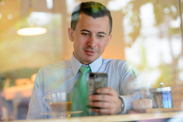 Young businessman using phone at the coffee shop