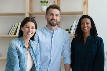 Group portrait of multiracial colleagues posing in modern office show unity and success, diverse multiethnic businesspeople coworkers look at camera posing in boardroom together, teamwork concept