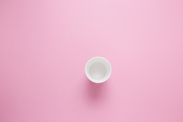 Paper cup for hot coffee or tea on a pink isolated background.