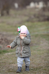 Little girl walks on a green spring field, a child walk in nature