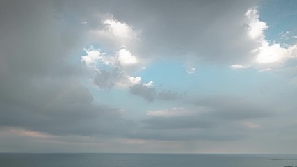 A vertical pan down aerial timelapse of fluffy white clouds filling a blue sky and then disappearing over Lake Michigan on the north side of Chicago and Foster Beach during sunset. - Powered by Adobe