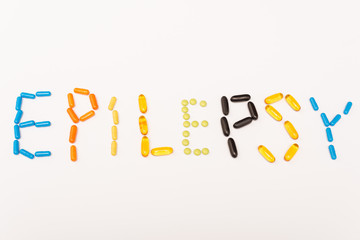 Top view of lettering epilepsy from colorful pills isolated on white