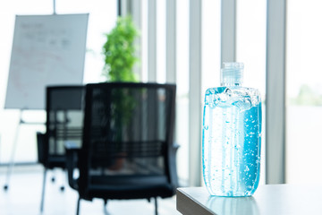 blue alcohol gel pump bottle for use in hand washing placed on table in workplace or hospital, prevent germs protect from coronavirus or covid-19 virus world pandemic,health care and medicine concept