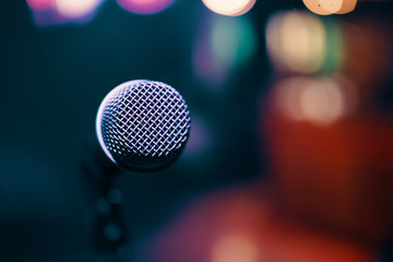 Cancelled concert. restaurants business are losing money. Microphone on colorful background. Close-up of retro microphone at concert.