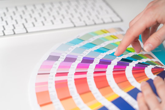 Graphic designer works on the choice of palette colors for creative business