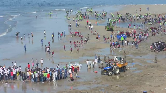 Group of asian people cleaning up the beach with plastic bags full of garbage. People with environment and volunteering concept.