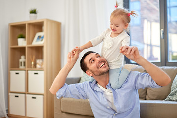 Fototapeta premium family, parenthood and fatherhood concept - happy father riding little baby daughter on his neck at home