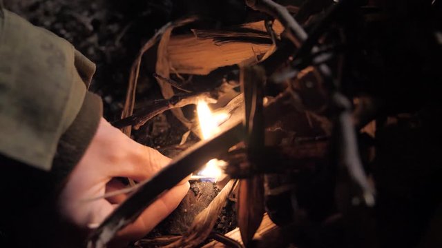 Man in military uniform lights fire on street