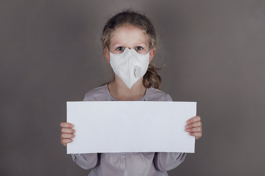 Little Girl In Medical Mask Is Holding Blank White Poster.