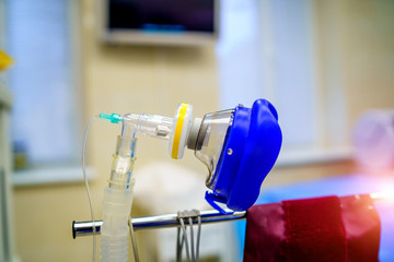 Oxygen mask as part of artificial lungs ventilation machine in surgery room, closeup. COVID-19 and...