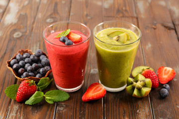 smoothie- fruit juice with strawberry and kiwi on wood background