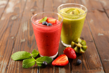 smoothie- fruit juice with strawberry and kiwi on wood background