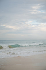 Fototapeta na wymiar The coast of the Indian Ocean at dawn in Sri Lanka in March 2020. Calm beautiful water and azure blue waves