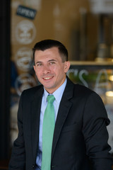 Fototapeta premium Happy young businessman smiling at the coffee shop outdoors