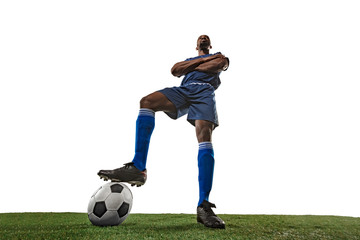 Football or soccer player on white background with grass. Young male sportive model training,...