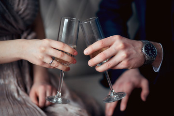 champagne glass in a woman's hand and a man's hand, romantic evening