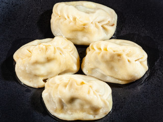 few of boiled Manti on black plate
