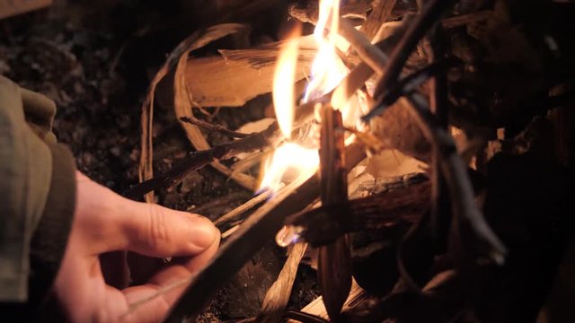 Man in military uniform lights fire on street