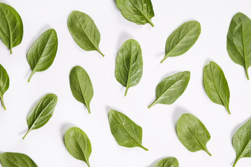 Clean eating concept. Leaves ripe juicy freshly picked organic baby spinach greens laid in pattern, isolated on white background. Healthy diet for spring summer detox. Vegan raw food. Close up.