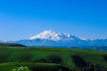 Dawn on the Gumbashi pass, view of mount Elbrus - the highest point in Russia. In summer, meadows bloom in Karachay-Cherkessia, and it always snows on the top of Elbrus