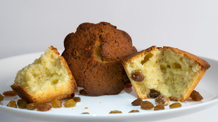 Sweet homemade cupcake with raisins on a white plate.