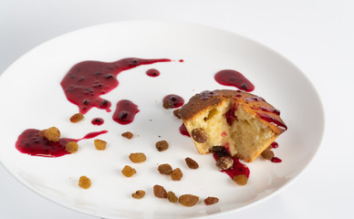 Sweet homemade cupcake with raisins on a white plate.