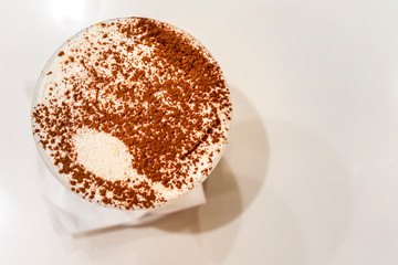 Tiramisu in a glass sprinkled with cocoa, trace from a spoon