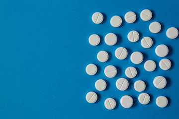 many white pills on a blue background