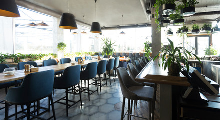 Empty cafe or bar interior with long table with chairs