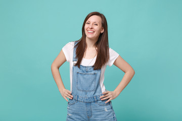 Smiling young brunette woman girl in casual denim clothes posing isolated on blue turquoise...