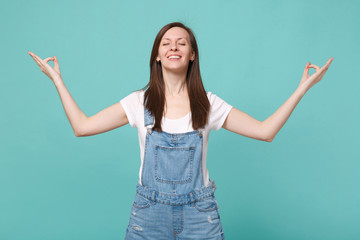Smiling young woman girl in casual denim clothes isolated on blue turquoise background. People...