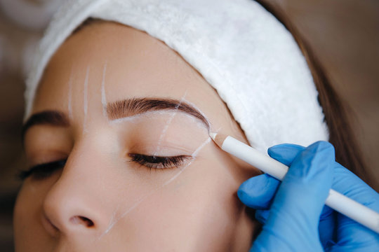 Brow marking and measuring before microblading. Permanent brow make-up. White brow paste.