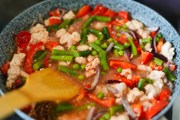 Thai Panang chicken Curry in a frying pan on the stove. Cooking. Boiling. Phanaeng Curry is a Thai dish with chicken, red curry sauce and vegetables. Thai cuisine. Thai food.