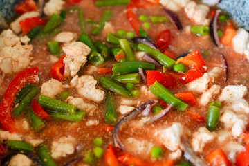 Thai Panang chicken Curry in a frying pan on the stove. Cooking. Boiling. Phanaeng Curry is a Thai dish with chicken, red curry sauce and vegetables. Thai cuisine. Thai food.