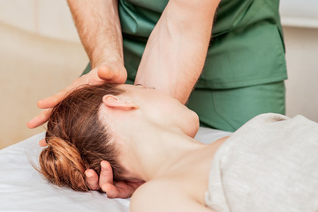 Fototapeta na wymiar Head massage of woman by hands of massage therapist close up.