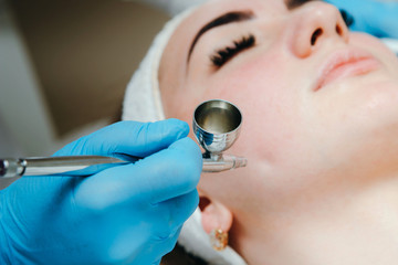 Woman receiving face treatment in beauty spa salon. Oxygen dermapen therapy. Skin treatment.